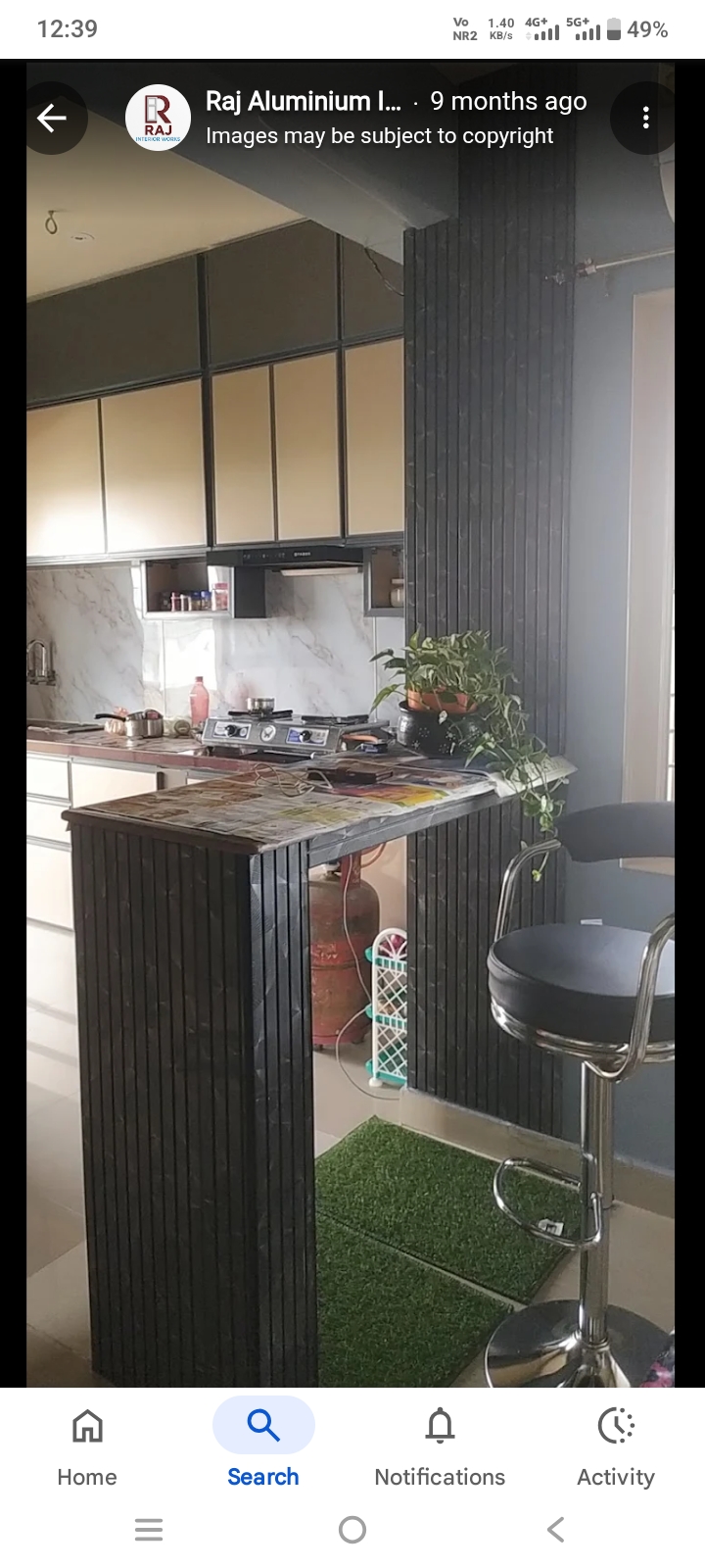 Open-plan kitchen with aluminium cabinets and breakfast counter