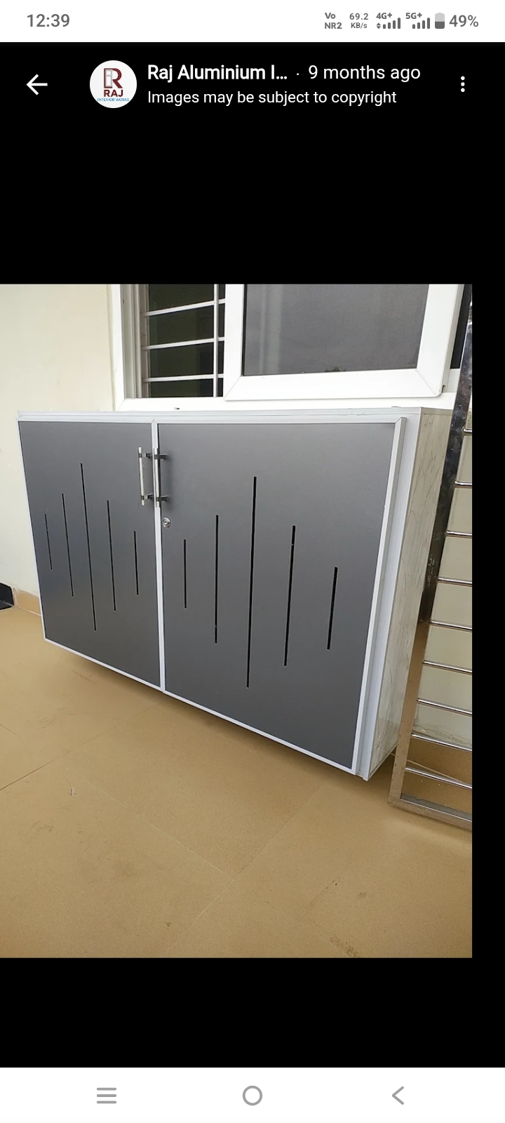Grey aluminium storage cabinet beneath a window